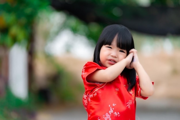 Retrato hermosa niña asiática en vestido CheongsamGente de TailandiaFeliz concepto de año nuevo chinoFeliz niña asiática en vestido tradicional chino