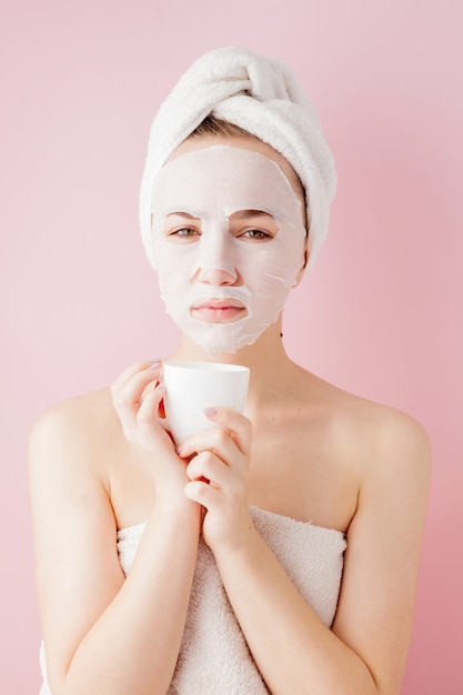 Retrato de una hermosa niña en bata de baño con una taza de té, concepto de relajación mujer rubia vestida con albornoz y toalla