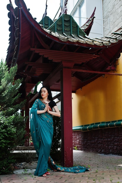 Retrato de hermosa niña brumette india o modelo de mujer hindú contra la casa tradicional japonesa