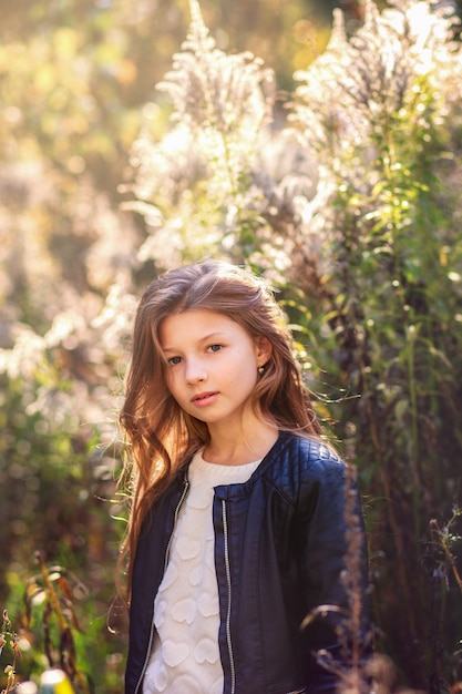 Retrato de una hermosa niña con cabello largo en la naturaleza en verano