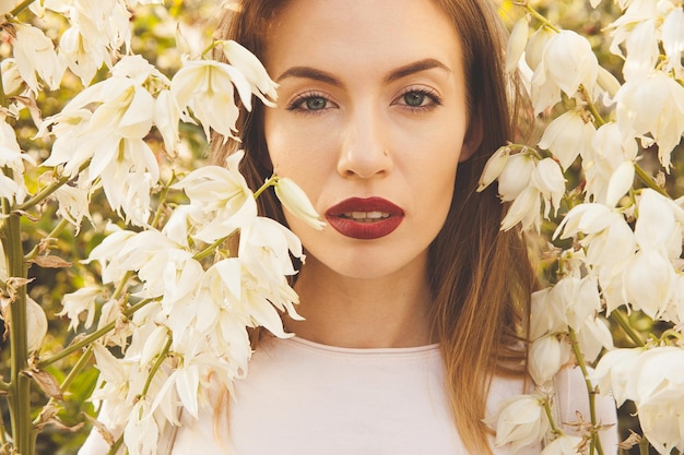 Retrato de una hermosa niña en campanas de flores blancas