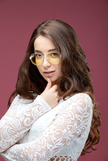 Retrato de una hermosa niña de gafas con una sonrisa.