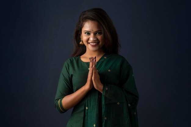 Retrato de una hermosa niña india en una pose de saludo a las manos de Namaste