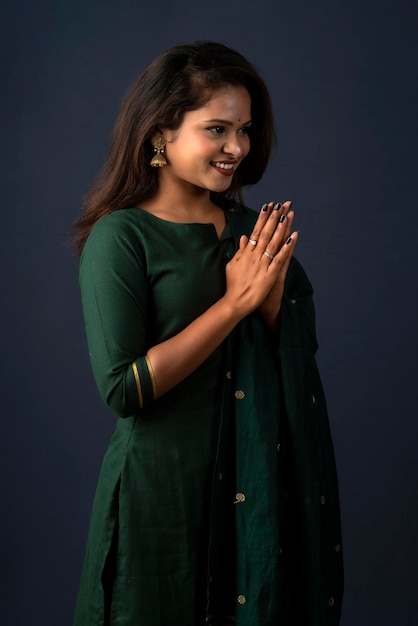 Retrato de una hermosa niña india en una pose de saludo a las manos de Namaste