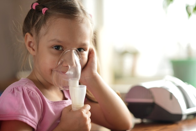 Foto retrato de una hermosa niña con inhalador