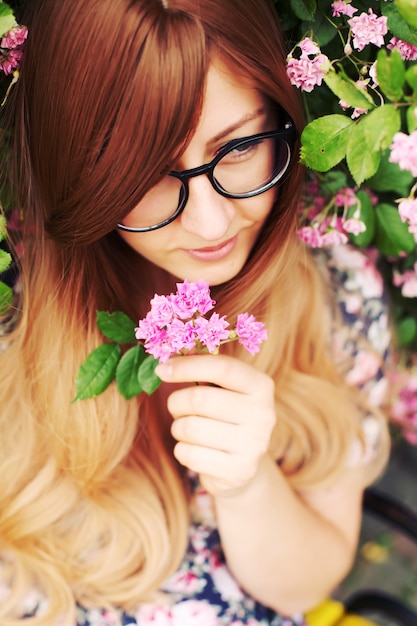 Retrato de una hermosa niña en el jardín de rosas de cerca