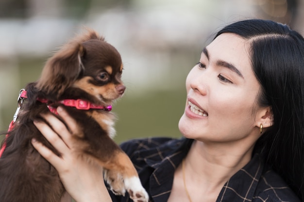 Retrato de una hermosa niña jugando con su adorable cachorro al aire libre en el parque público. Perrito con dueño pasa un día en el parque jugando y divirtiéndose. Mascota, amor colección de foto