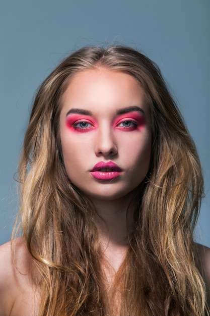 Retrato de una hermosa niña con maquillaje rosa