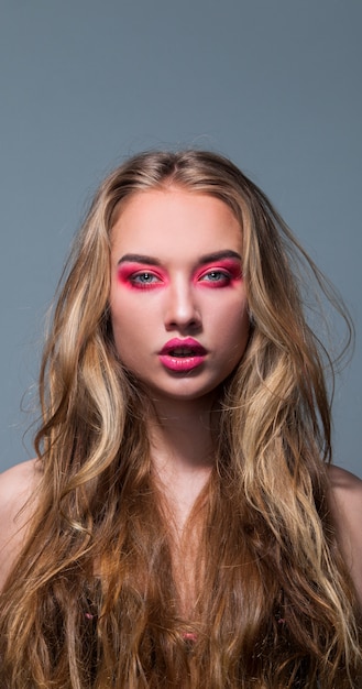 Retrato de una hermosa niña con maquillaje rosa