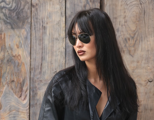 Retrato de una hermosa niña morena con una chaqueta de cuero negro