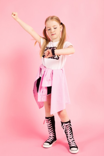 Retrato de una hermosa niña en pantalones cortos, una camiseta y zapatillas altas.