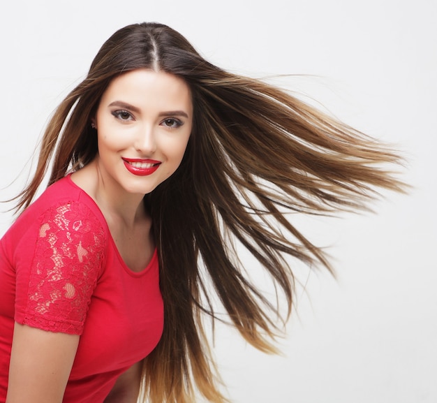 Retrato de una hermosa niña con el pelo ondeando sobre fondo blanco.