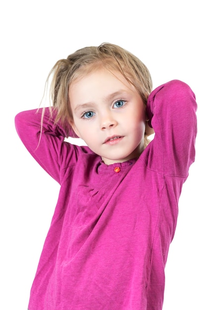 Retrato de una hermosa niña posando en la cámara con las manos detrás de la cabeza aislada en el fondo blanco