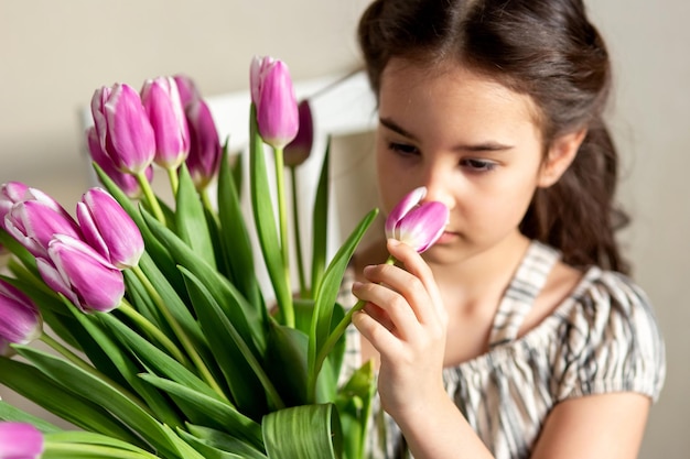 Retrato de una hermosa niña con un ramo de tulipanes