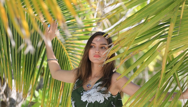 Retrato de una hermosa niña en un resort tropical de palmeras