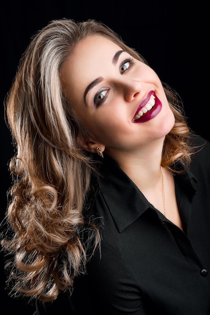 Retrato de hermosa niña sonriente feliz con maquillaje y peinado en estudio