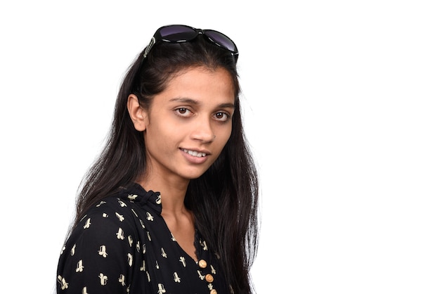 Retrato de una hermosa niña sonriente en gafas de sol sobre fondo blanco.