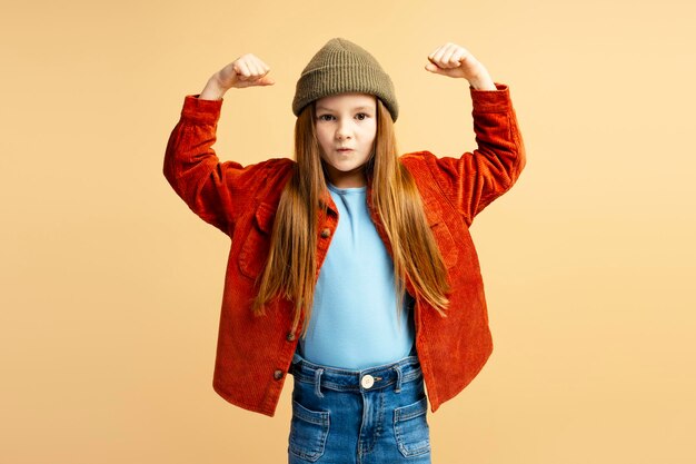 Retrato de una hermosa niña sonriente con ropa casual que muestra los músculos del bíceps