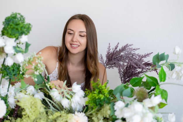 Retrato de una hermosa niña sonriente con un vestido rodeado de flores.