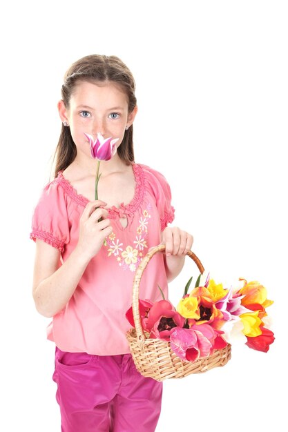 Retrato de hermosa niña con tulipanes en canasta aislado en blanco