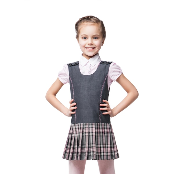 Foto retrato de una hermosa niña en uniforme escolar con mochila roja aislada en blanco