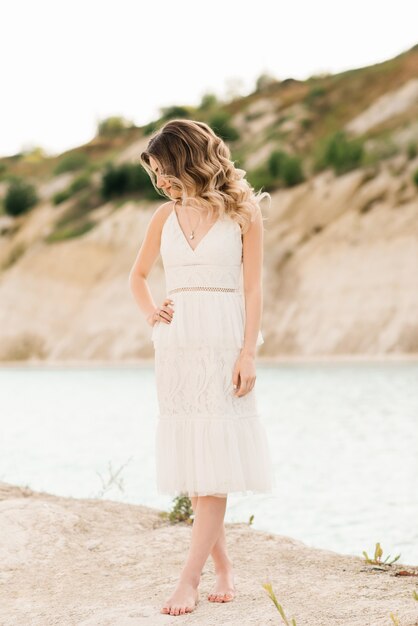 Retrato de una hermosa niña con un vestido blanco con cabello y maquillaje en el fondo del mar