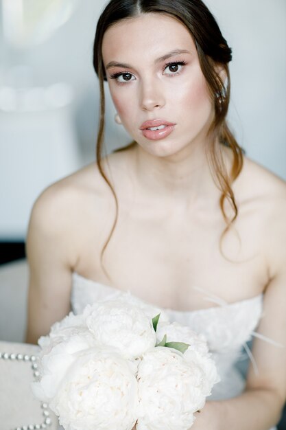 Retrato de una hermosa novia con el día de la boda de flores