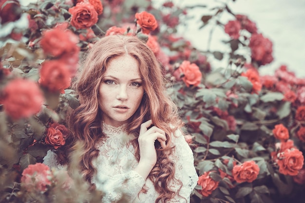 Retrato de la hermosa novia de pie en medio de las flores