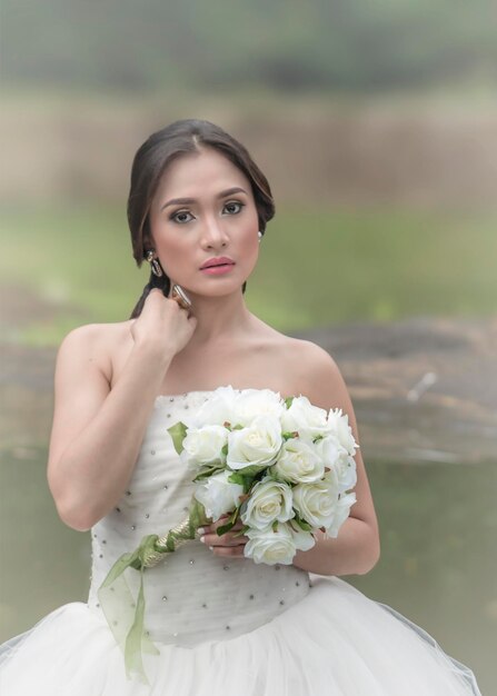 Retrato de la hermosa novia con un ramo de rosas blancas