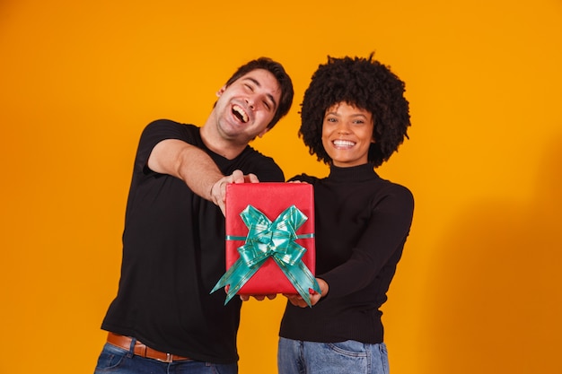 Retrato de una hermosa pareja en amarillo con un regalo