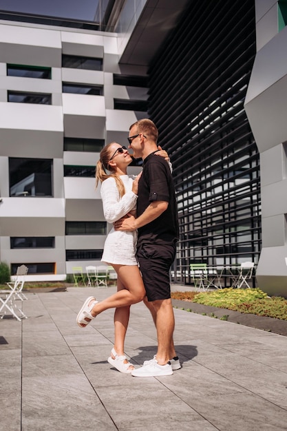 Retrato de una hermosa pareja elegante caminando por la calle durante las vacaciones de verano