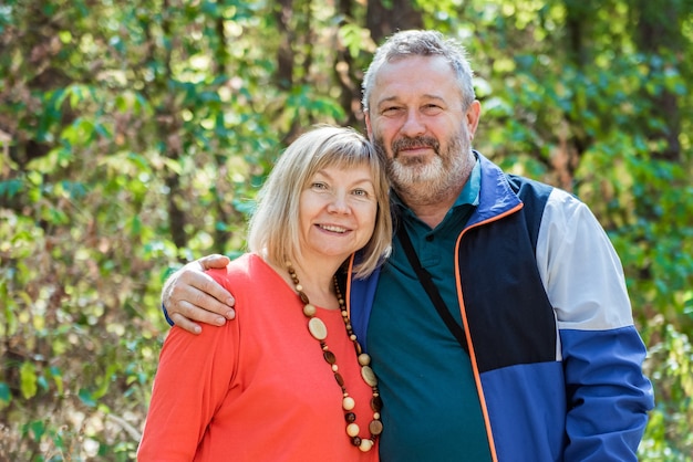 Retrato de hermosa pareja senior relajante en el parque de otoño