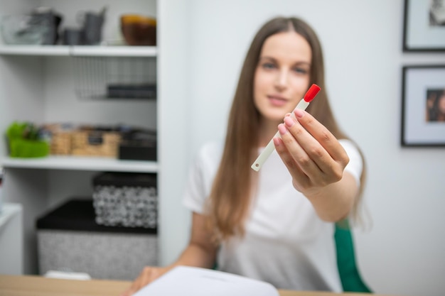 Retrato de una hermosa y sonriente clienta que muestra el color de las coloridas puntas de las uñas