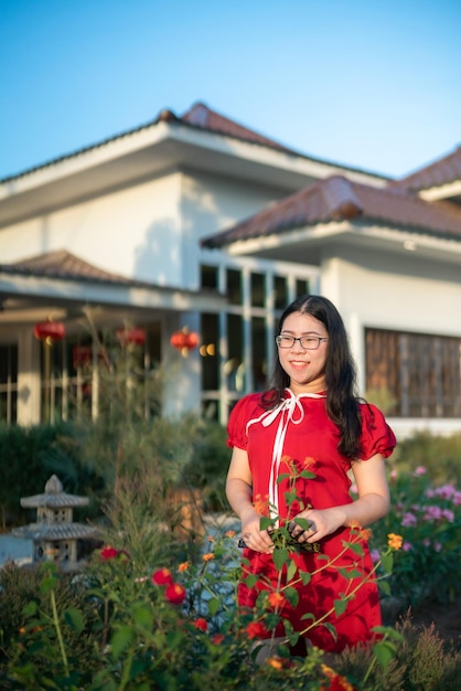 Retrato hermosas sonrisas mujer joven asiática vestida con decoración china tradicional roja y sosteniendo un Fanning chino para el Festival de Año Nuevo Chino en el café restaurante chino