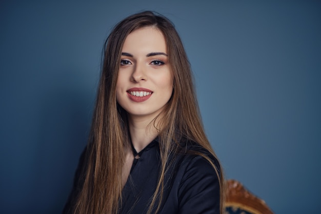 Retrato, de, hermoso, feliz, mujer joven, en, pared azul