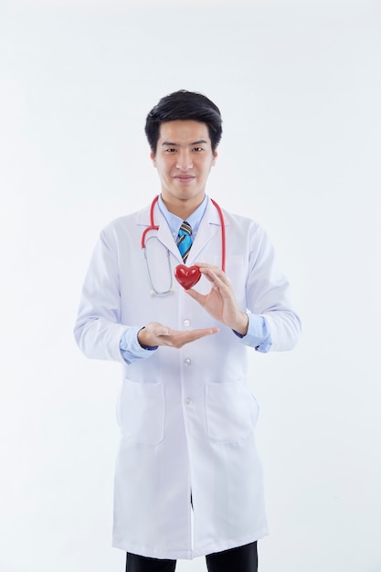 Retrato hermoso joven médico asiático hombre mostrar corazón para un símbolo de amor sobre fondo blanco aislado