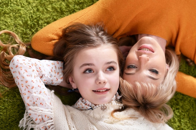 retrato, de, hermoso, madre, con, hija, acostado, en, alfombra verde