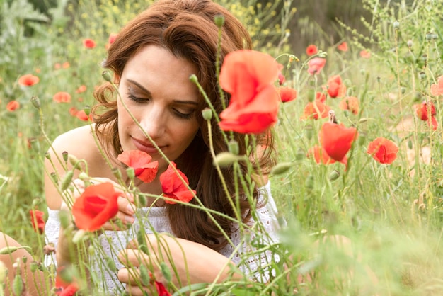 retrato, de, un, hermoso, mujer joven, sentado, en, el, amapola, campo