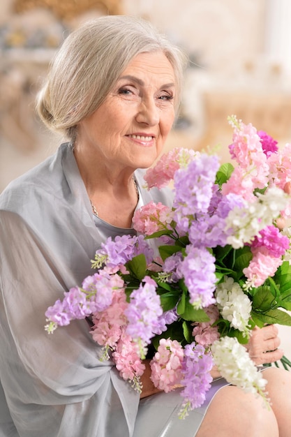 retrato, de, hermoso, mujer mayor, posar, con, flores