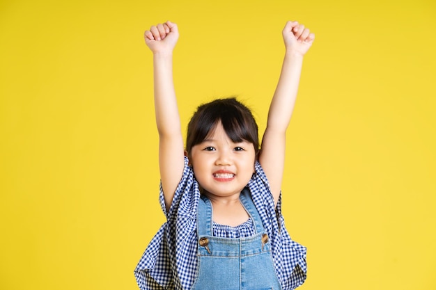 retrato, de, un, hermoso, niña asiática, aislado, en, fondo amarillo