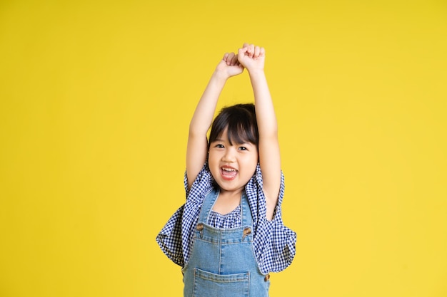 Retrato, de, un, hermoso, niña asiática, aislado, en, fondo amarillo