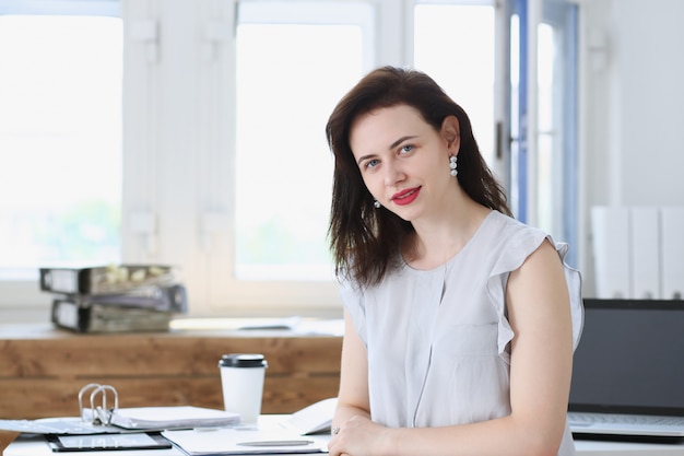 El retrato hermoso sonriente de la empresaria en el lugar de trabajo mira in camera. Trabajador de cuello blanco en el mercado de intercambio de espacio de trabajo oferta de trabajo contador público certificado concepto de funcionario de ingresos internos