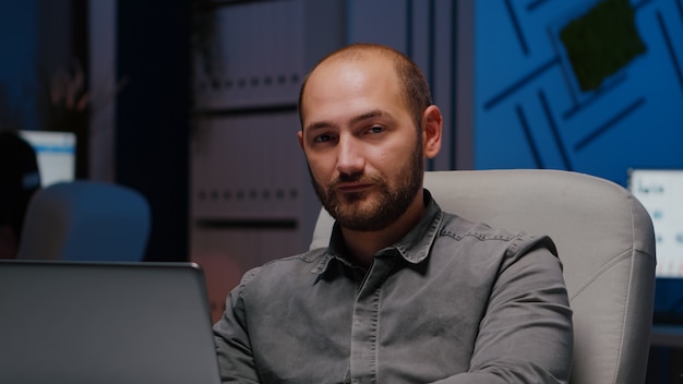 Retrato de hombre adicto al trabajo agotado gerente escribiendo estrategia financiera usando la computadora portátil mien ...