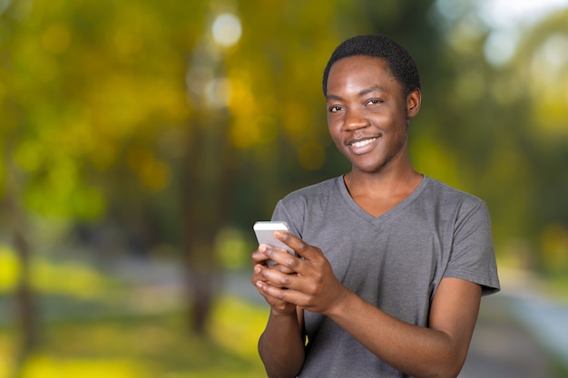 Retrato de un hombre africano sonriente con smartphone