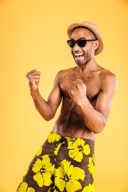 Foto retrato de un hombre afro feliz celebrando su éxito aislado en una pared blanca