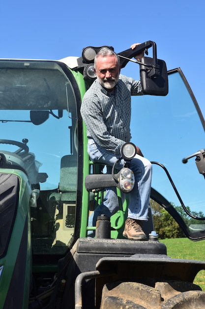 Retrato de un hombre agricultor y tractor