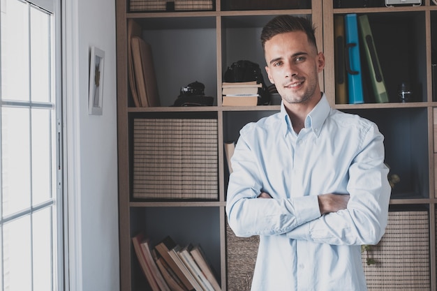 Retrato de un hombre alegre joven y feliz sonriendo mirando a la cámara divirtiéndose. Foto de cabeza de una persona del sexo masculino que trabaja en casa en la oficina.