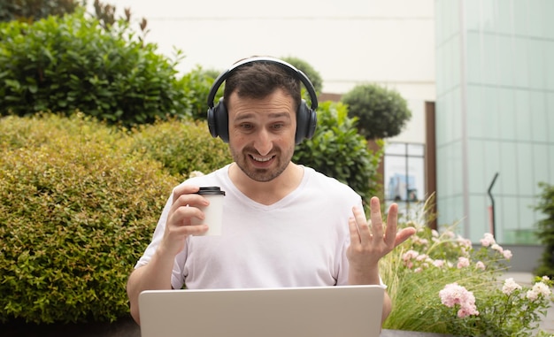 Retrato de un hombre alegre que tiene una videollamada en una computadora portátil