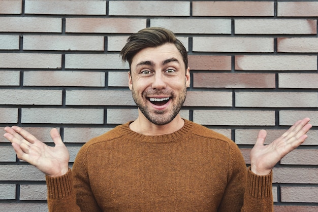 Retrato de hombre alegre en retrato de estilo de vida de fondo de pared de ladrillo de ciudad urbana. Concepto de carrera y emprendimiento.