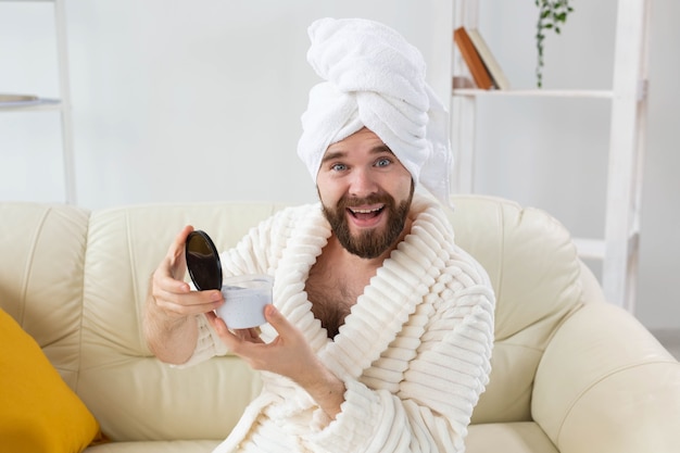 Retrato de hombre aplicando crema eficaz en la piel del rostro. Spa en casa, cuidado del cuerpo y de la piel por concepto masculino.